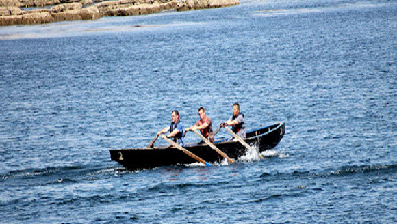 Men rowing a currach in the sea